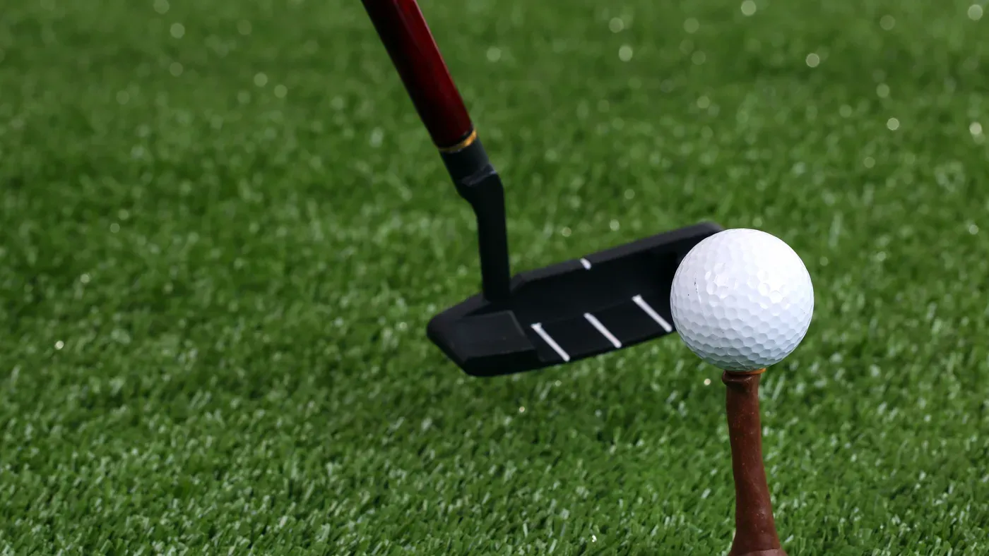 Närbild på bästa putter vid golfboll på tee