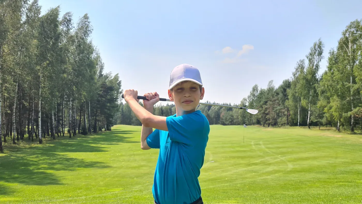 Barn puttar med klubba ur golfset för barn
