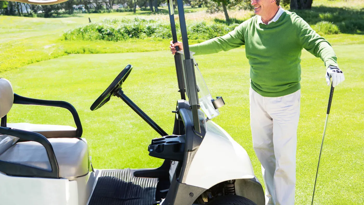 Golfspelare fäller upp skärmen på bästa elgolfvagn på banan