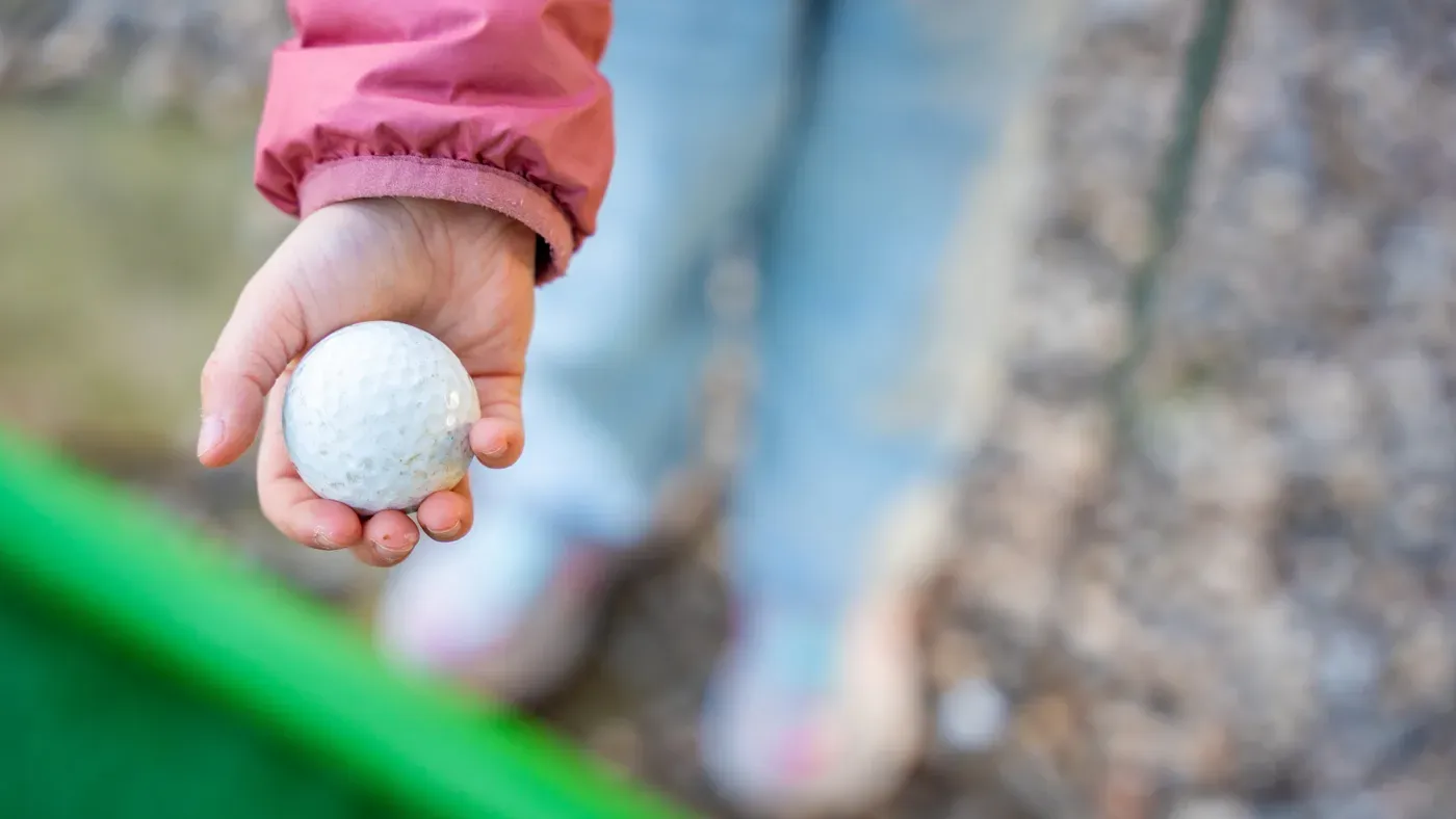 Pojke svingar klubba ur sitt golfset för junior